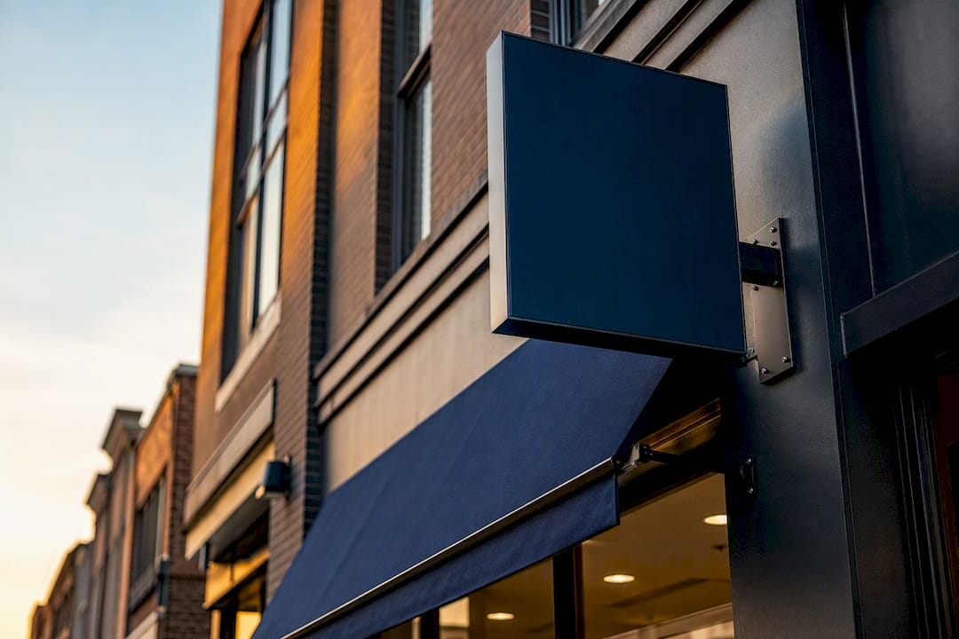 Side view of storefront blade sign and awning