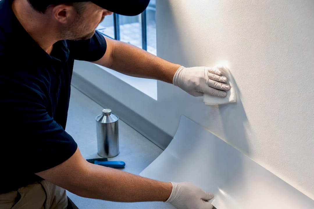 Installer cleaning wall before applying decal